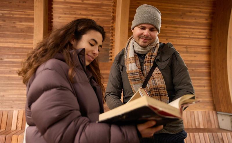 Students holding books talking