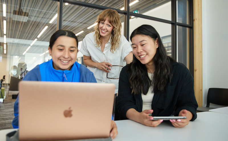 Two students and an academic advisor smiling together