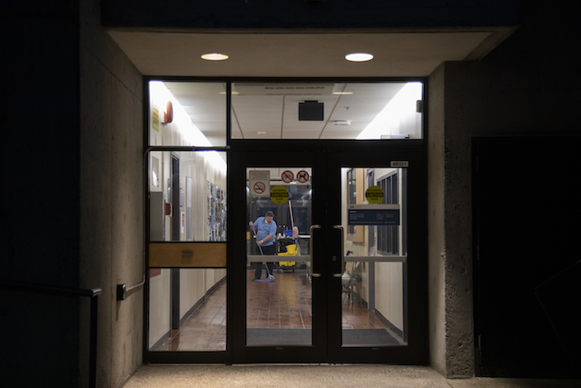 A cleaner works in the Arbutus building on March 25, 2020.