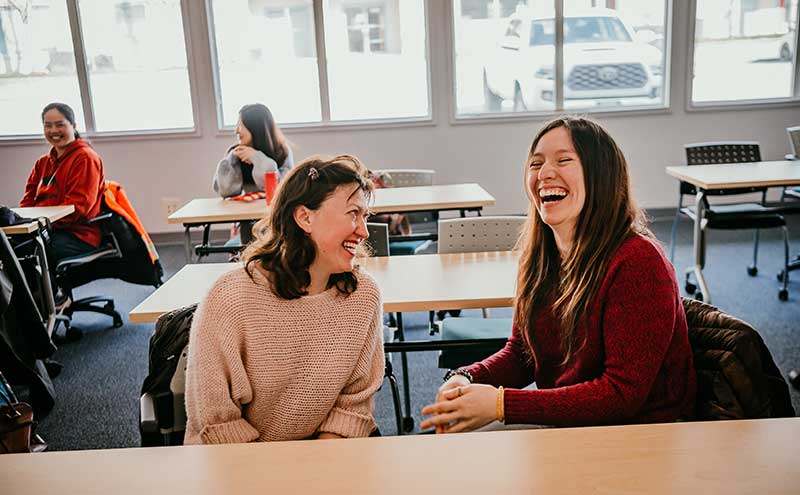 CapU students sharing a laugh in class.