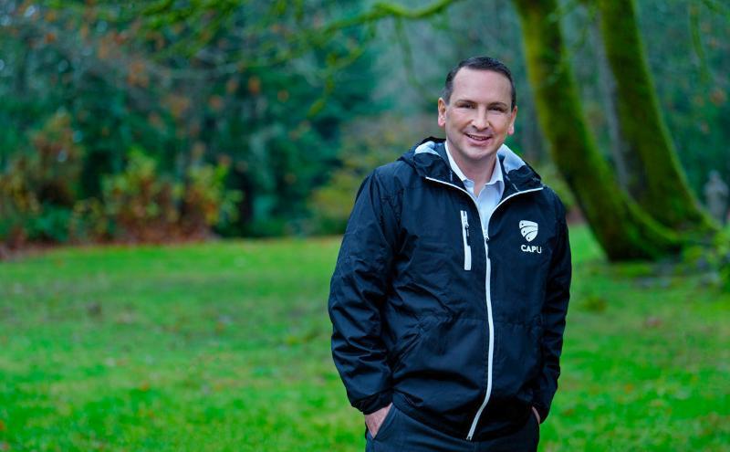 President Dewling in a park wearing his new CapU jacket.