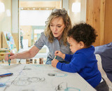 A CapU Early Childhood Care &amp; Education student in the Fulmer Centre with a chil