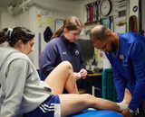 Kinesiology students wrapping an athlete