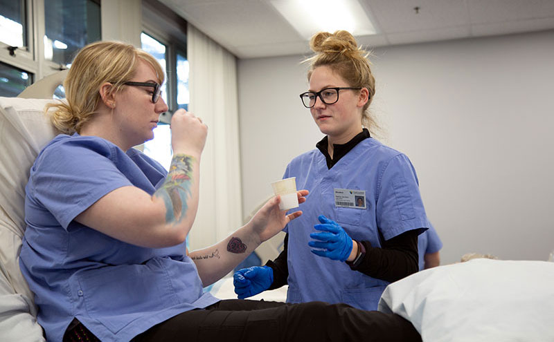 Students doing a patient-HCA roleplay with medication.
