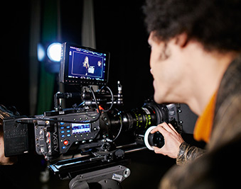 CapU student looking through a camera viewfinder.