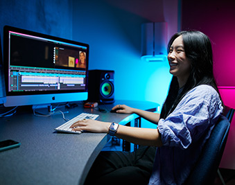 CapU student working at a video editing terminal.