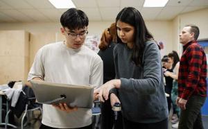 CapU Kinesiology students comparing notes on a tablet. 