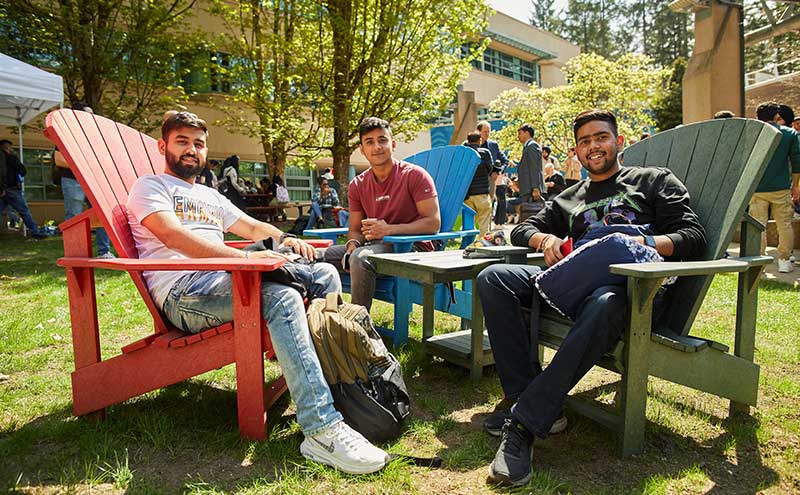 CapU students sitting in huge Adirondack chairs at Orientation.