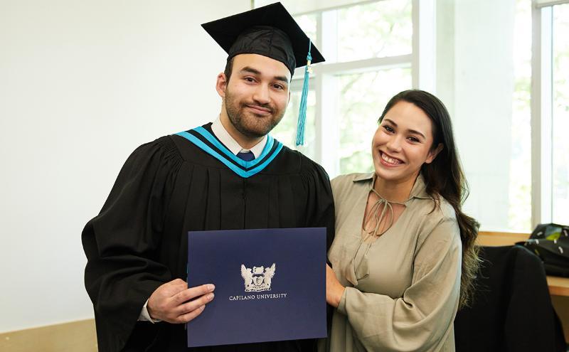 Student with friend holding degree