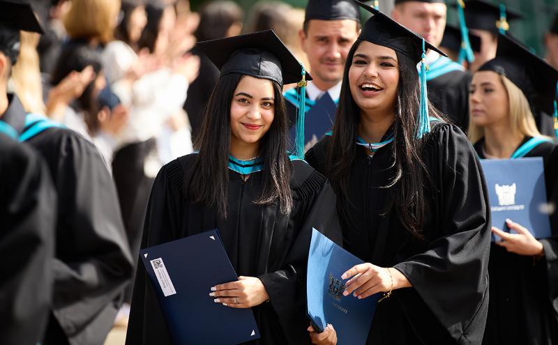 Students holding credentials at Convocation ceremony