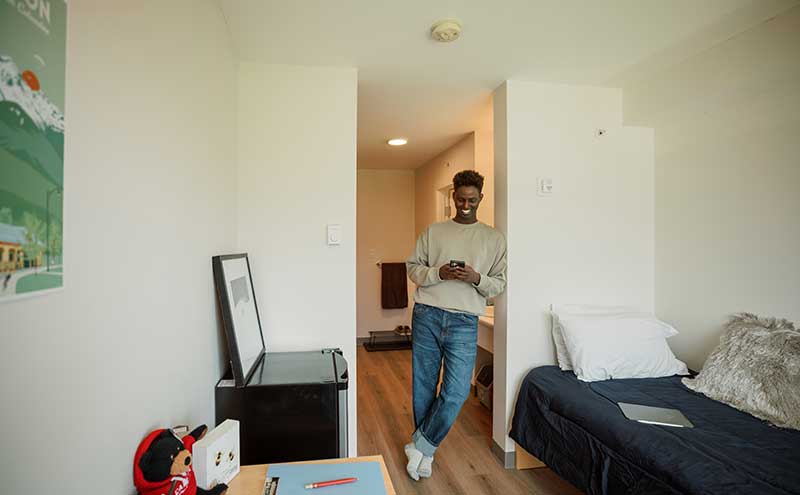 CapU student in his room at Squamish student housing.